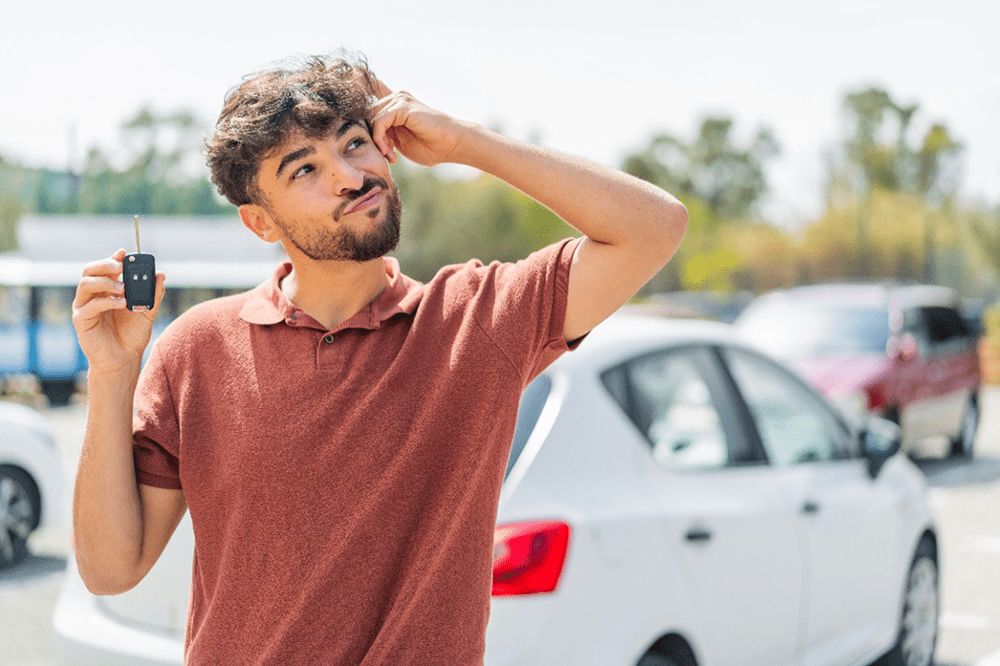 Homem segurando a chave do carro com dúvida      