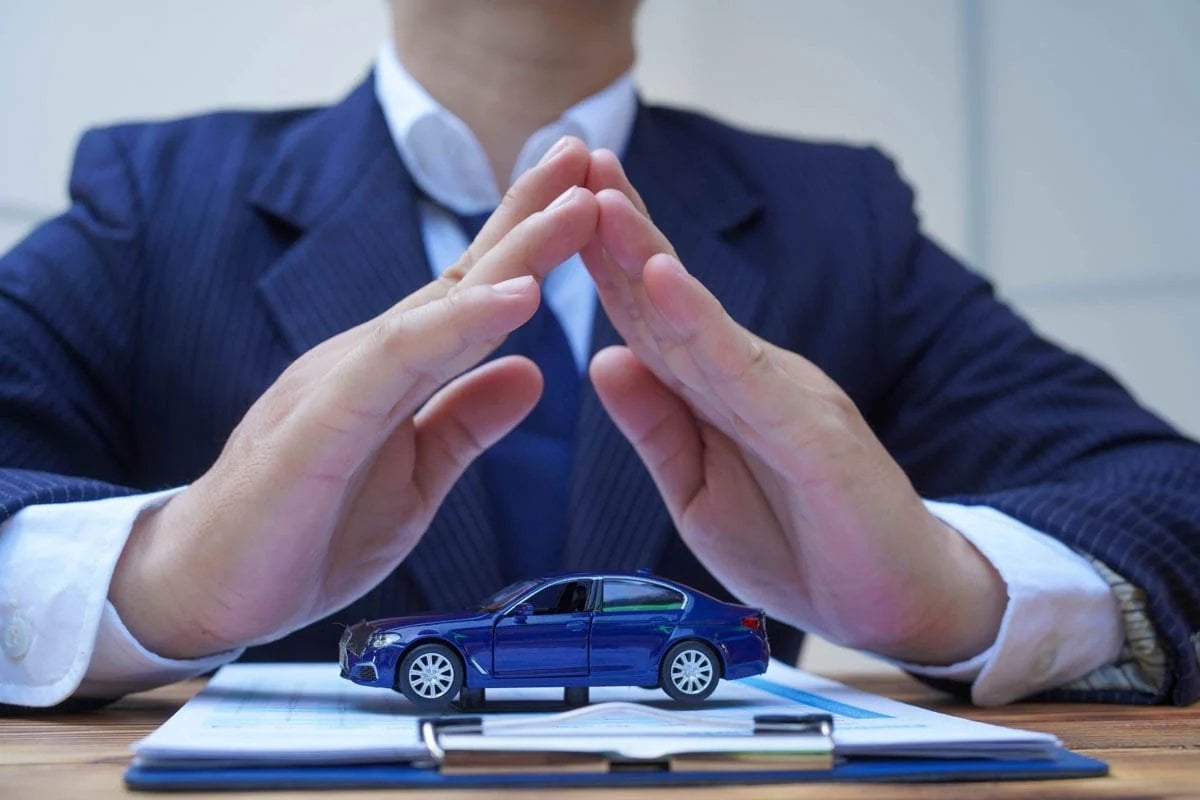 Corretor Allianz com contrato de seguro auto na mesa     