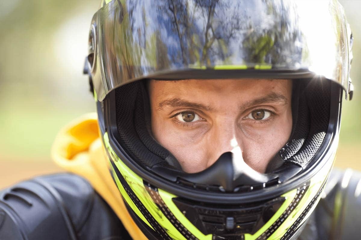 Rosto de um motociclista com o capacete aberto      