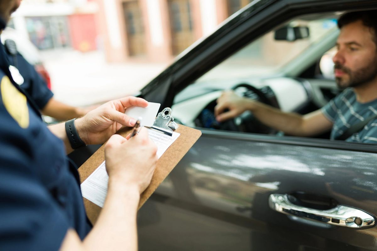 Motorista recebendo uma multa de um policial       