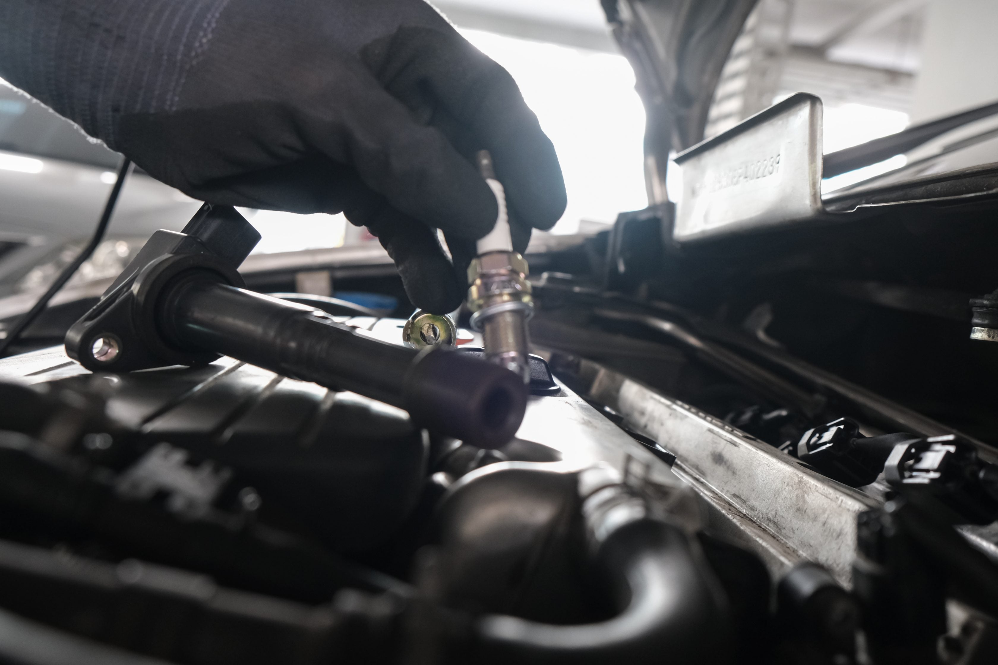 Mecânico retirando as velas de um veículo       