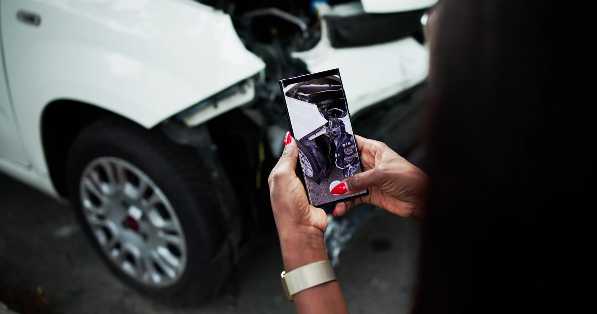 Mulher fotografando o carro após colisão        