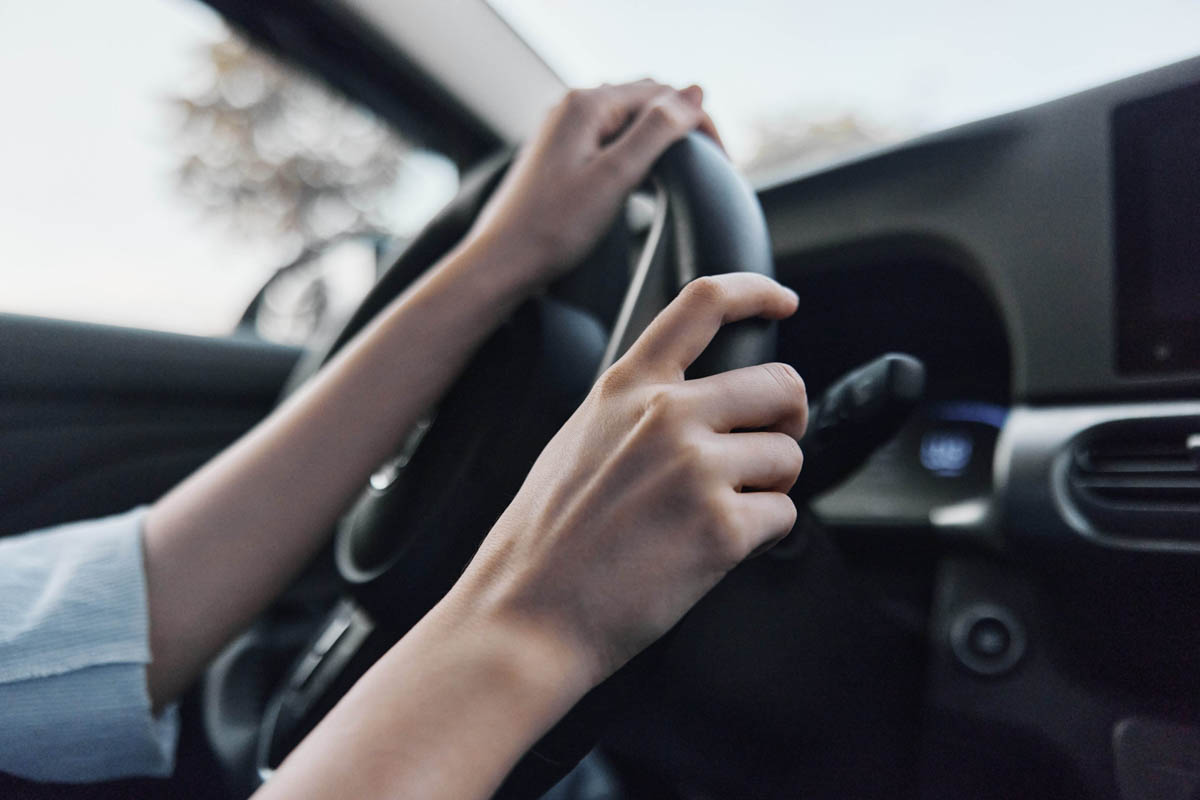 Motorista segurando o volante de um veículo       