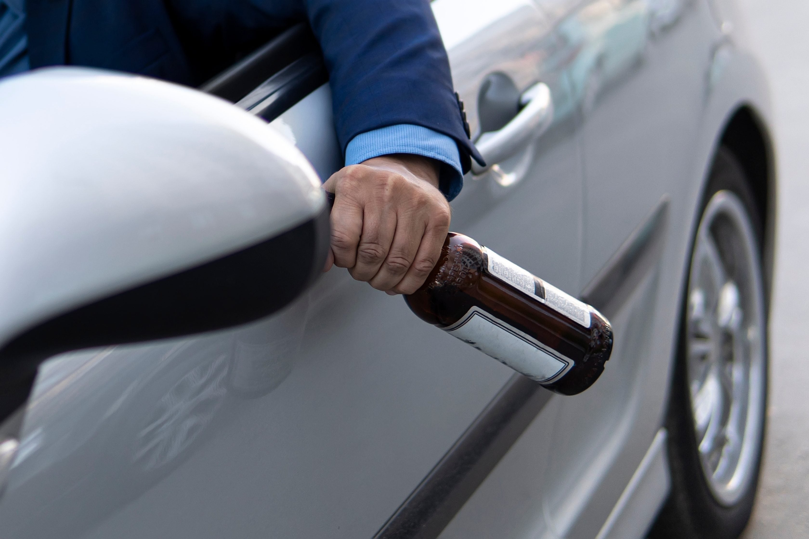 Motorista dirigindo seu carro e consumindo bebida alcoólica      