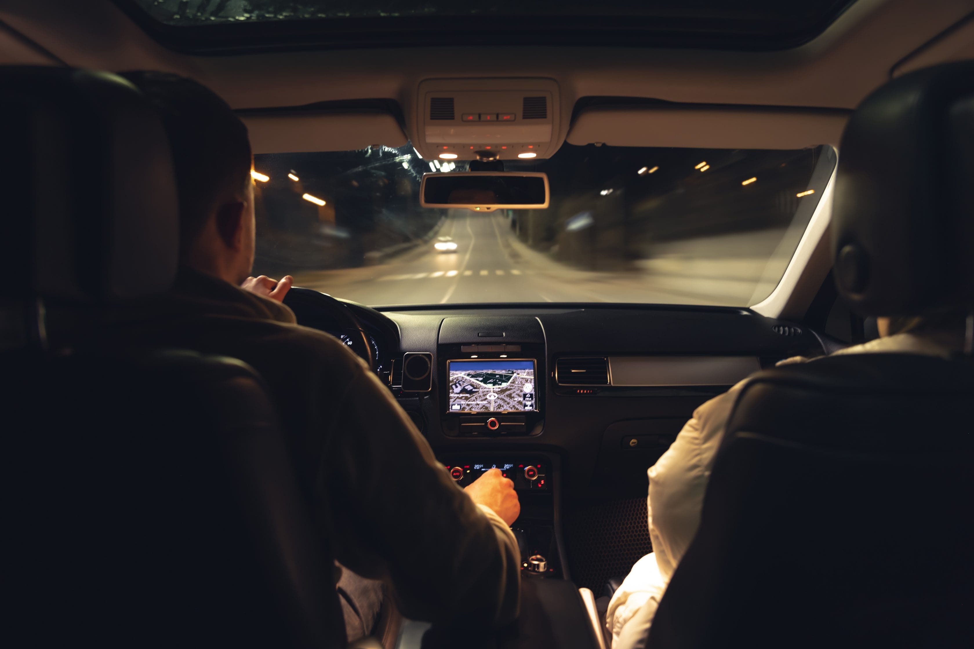 Casal dirigindo em uma estrada durante a noite 