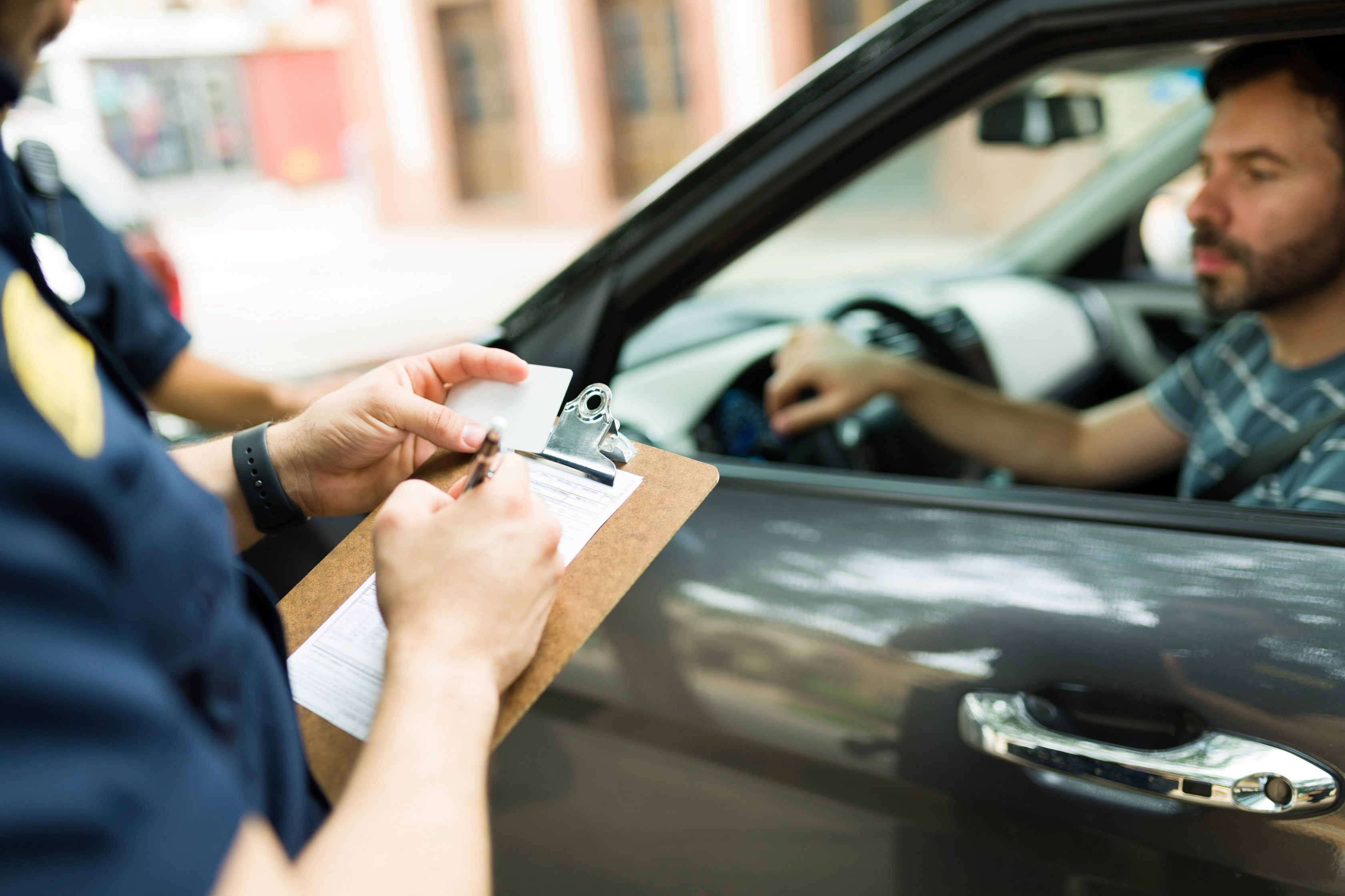 Oficial da CET aplicando uma multa em um motorista     