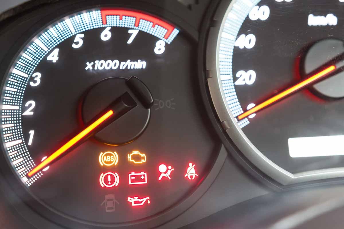 Painel de um carro com as luzes de alerta acesas    