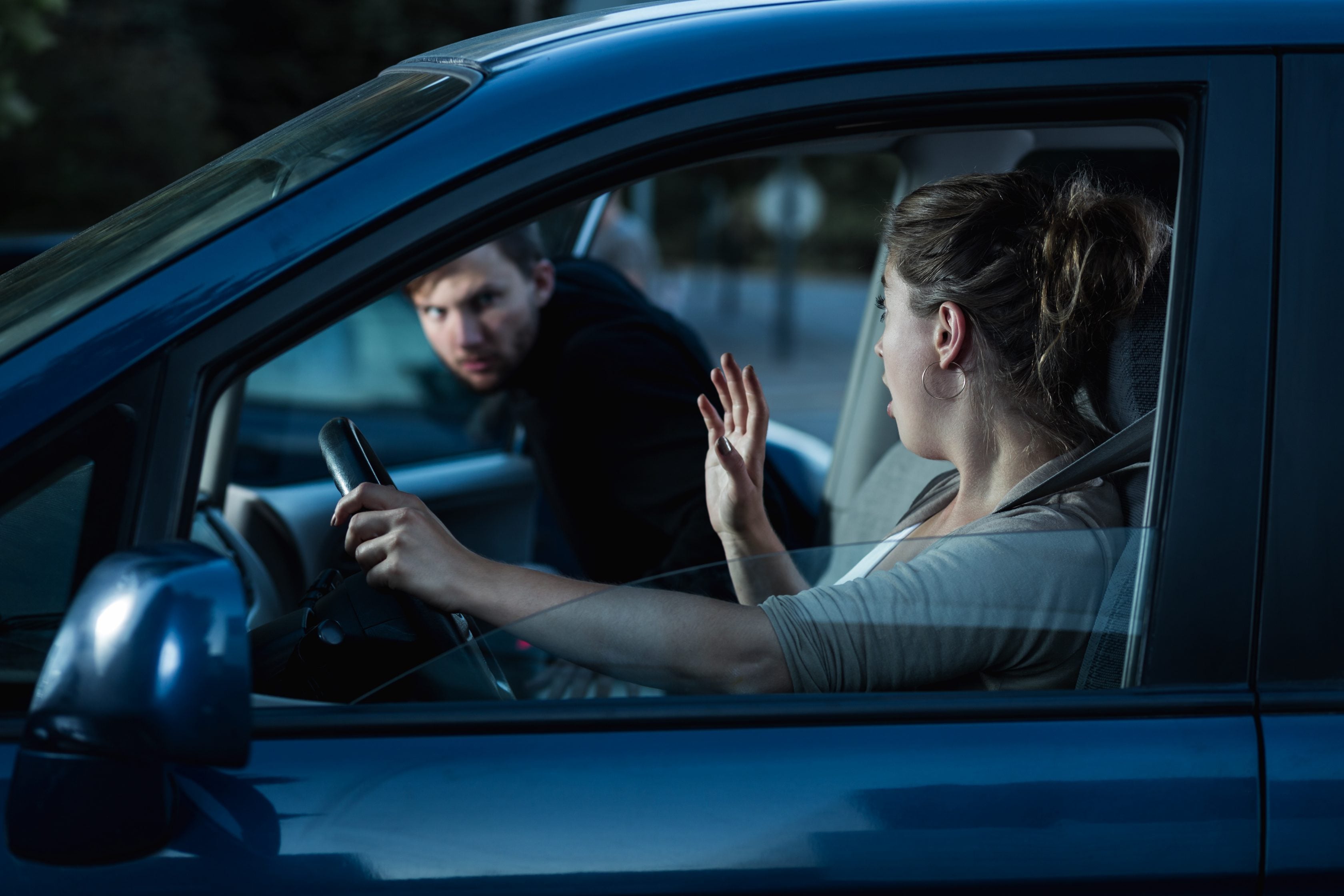 Ladrão roubando o carro de uma mulher       