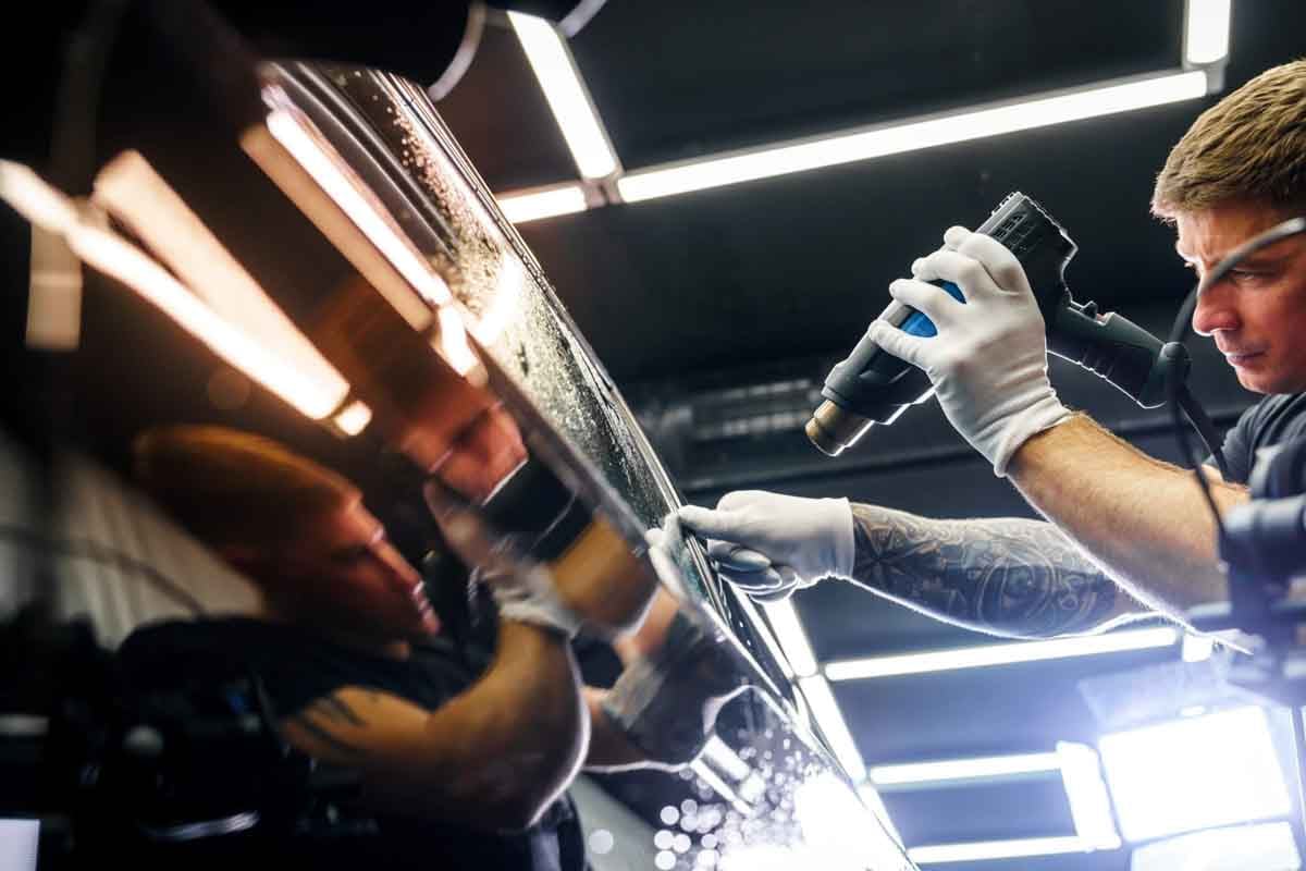 Instalador aplicando uma película no vidro do carro      