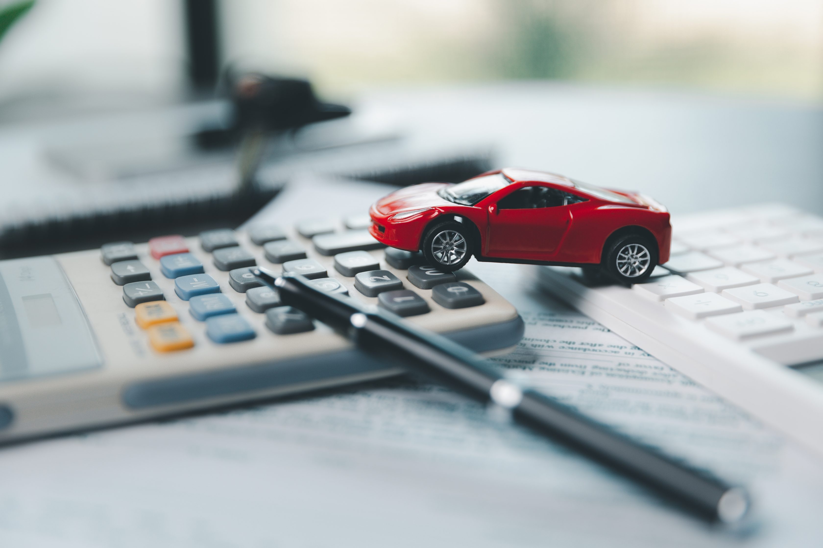 Miniatura de carro em cima de uma calculadora      