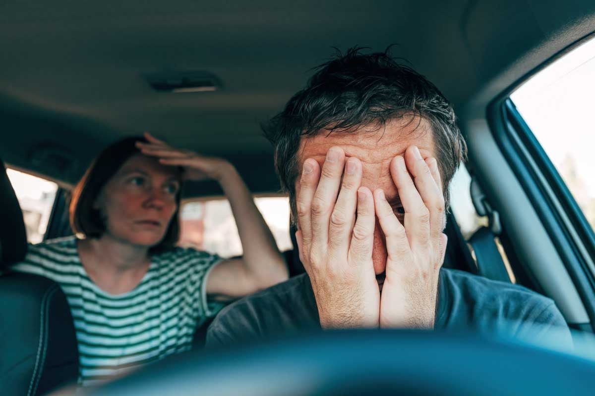 Homem e uma mulher dentro de um veículo quebrado     