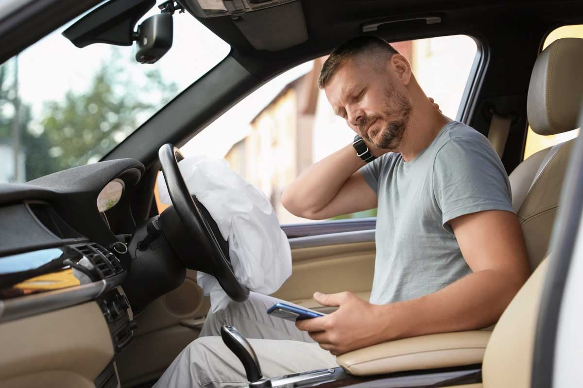 Homem usando o celular após uma colisão       