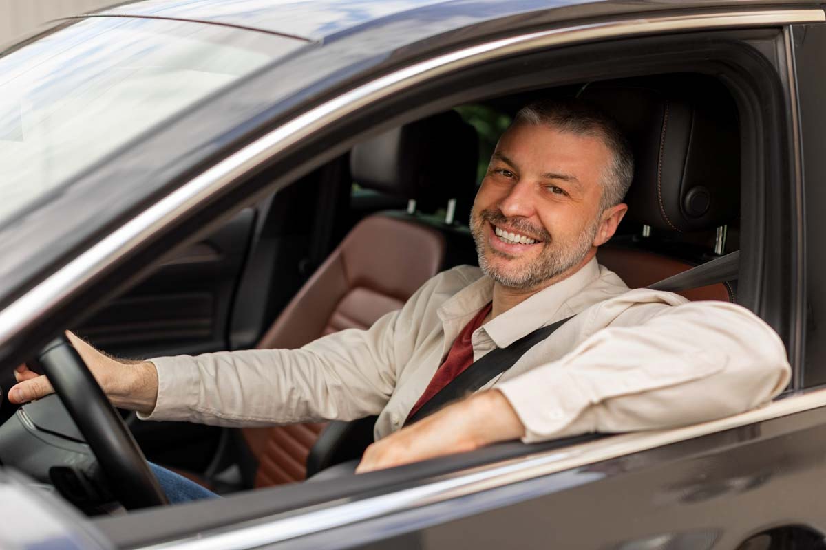 Homem dentro do seu carro sorrindo        