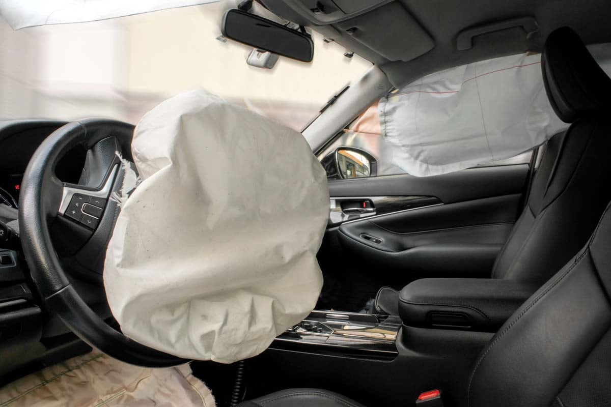 Parte interna de um veículo com os airbags estourados     