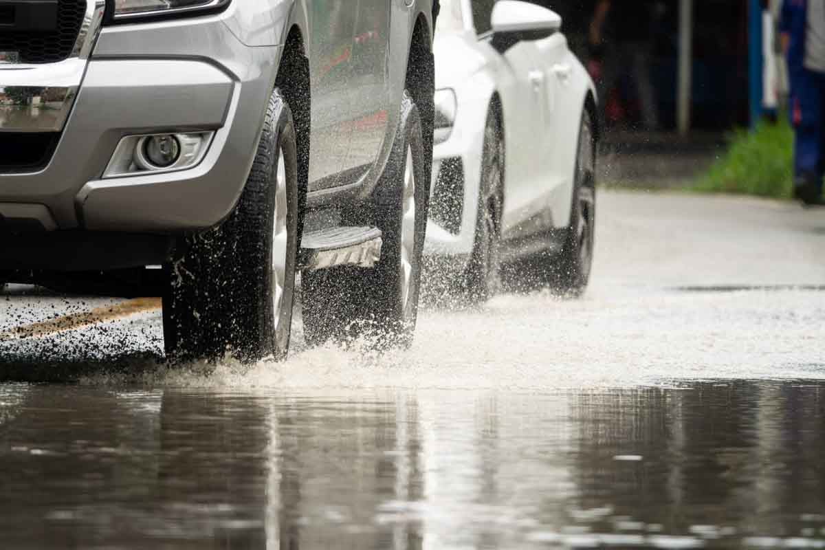 Veículos andando em uma rua em um dia chuvoso     