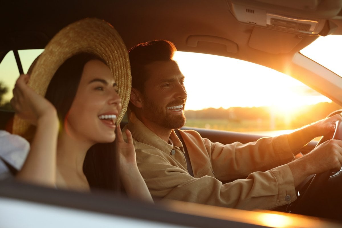 Casal dentro do carro sorrindo         