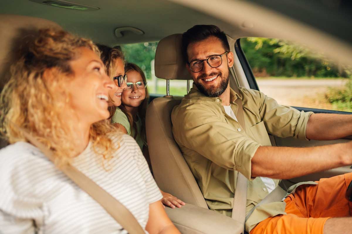 Família dentro do seu carro sorrindo        