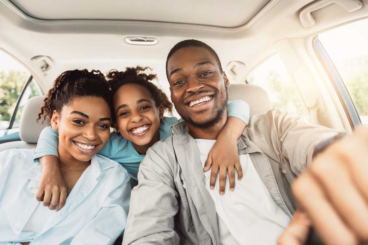 Família dentro do seu carro sorrindo        