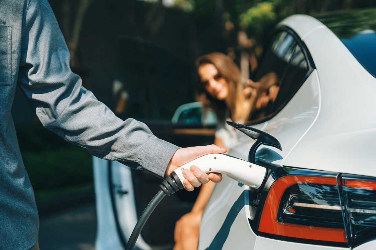 Homem realizando o carregamento do seu veículo elétrico      