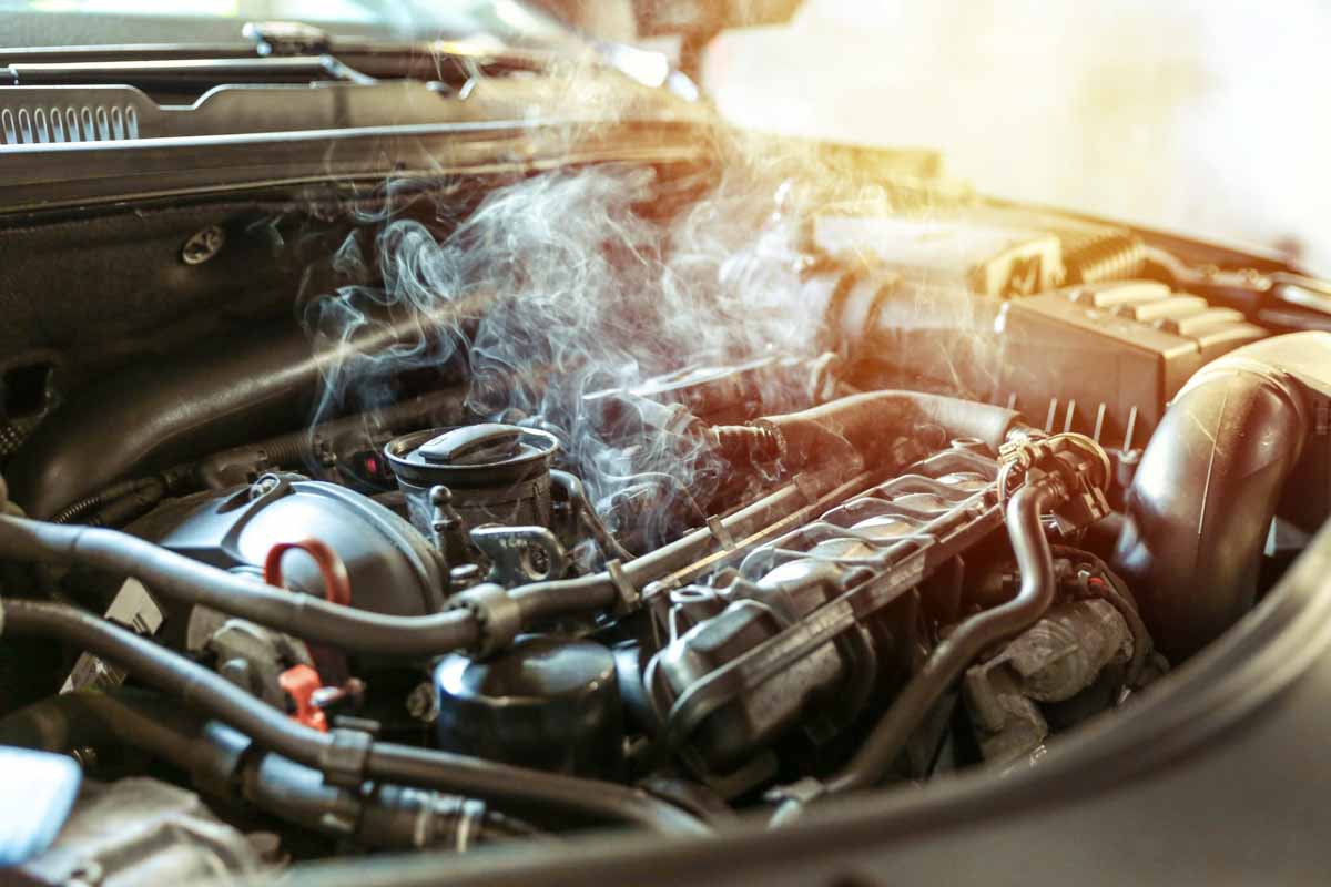 Motor de um carro com problemas soltando fumaça      