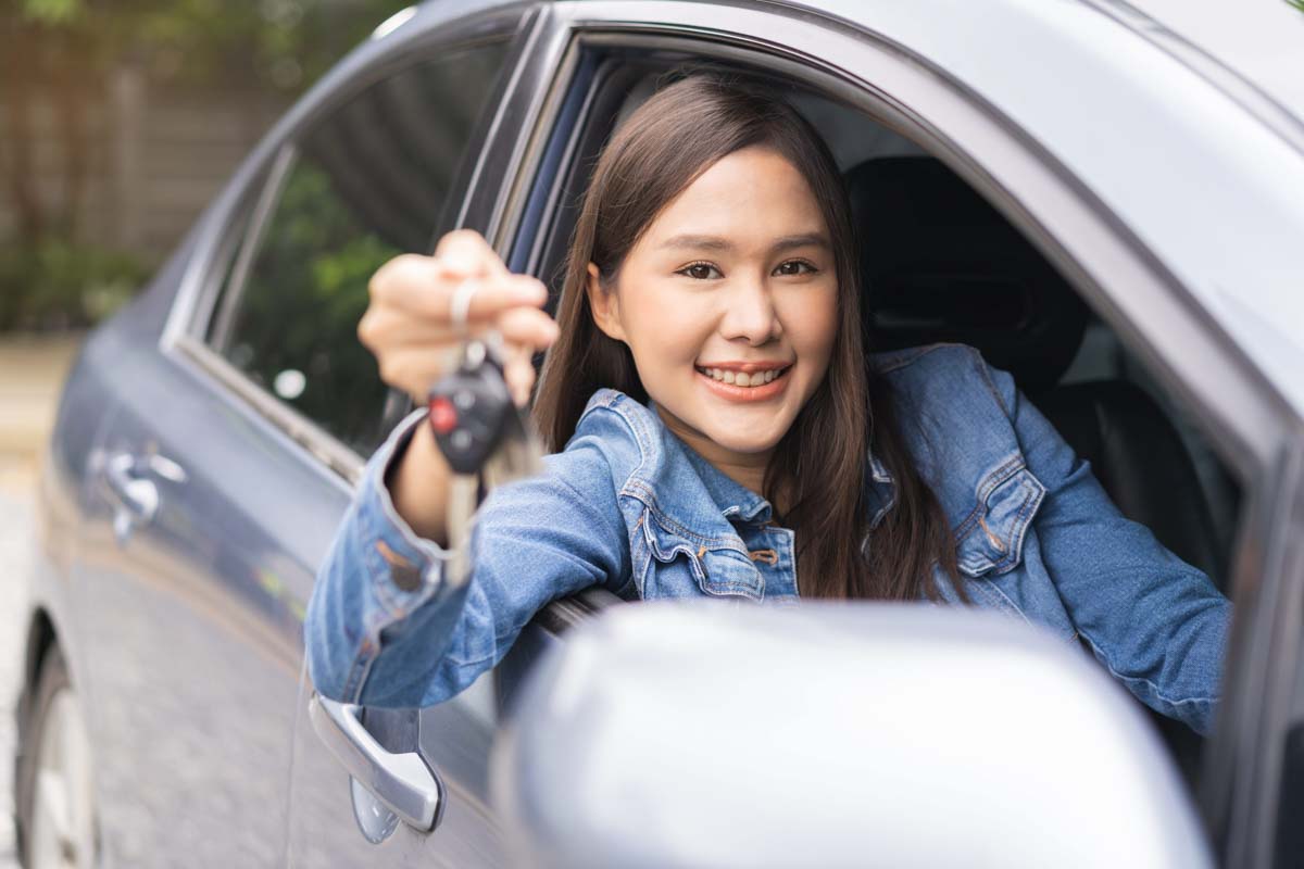 Mulher segurando a chave do carro sorrindo       
