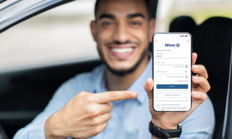 Homem segurando o celular e monstrando o app da Allianz Seguros   
