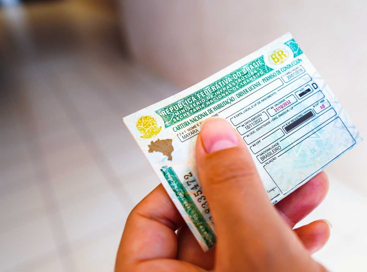 Pessoa segurando sua CNH          