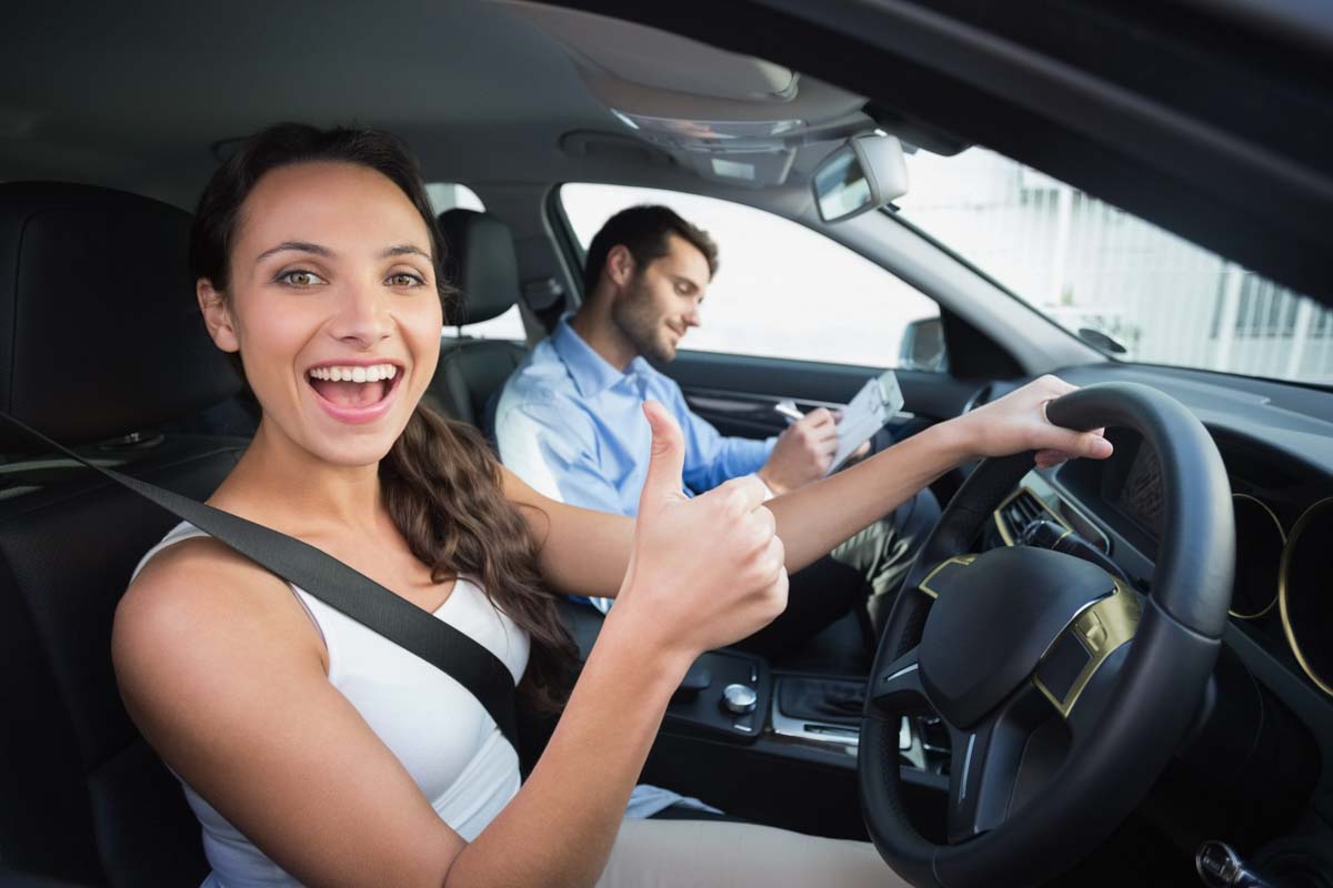 Mulher feliz ao concluir a prova prática para tirar a CNH   