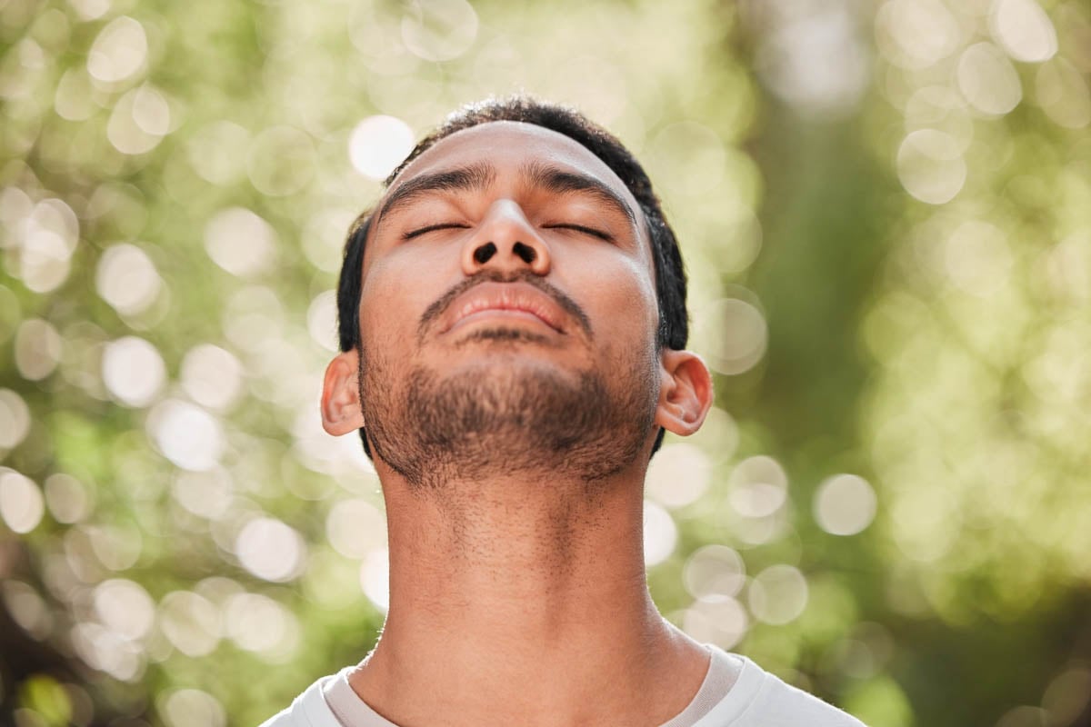 Homem fazendo meditação com os olhos fechados       