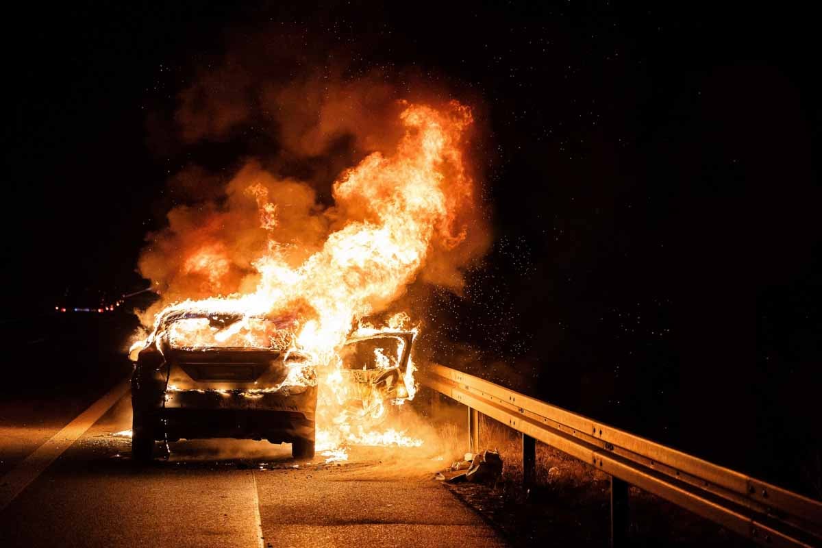 Veículo em chamas em uma estrada a noite      