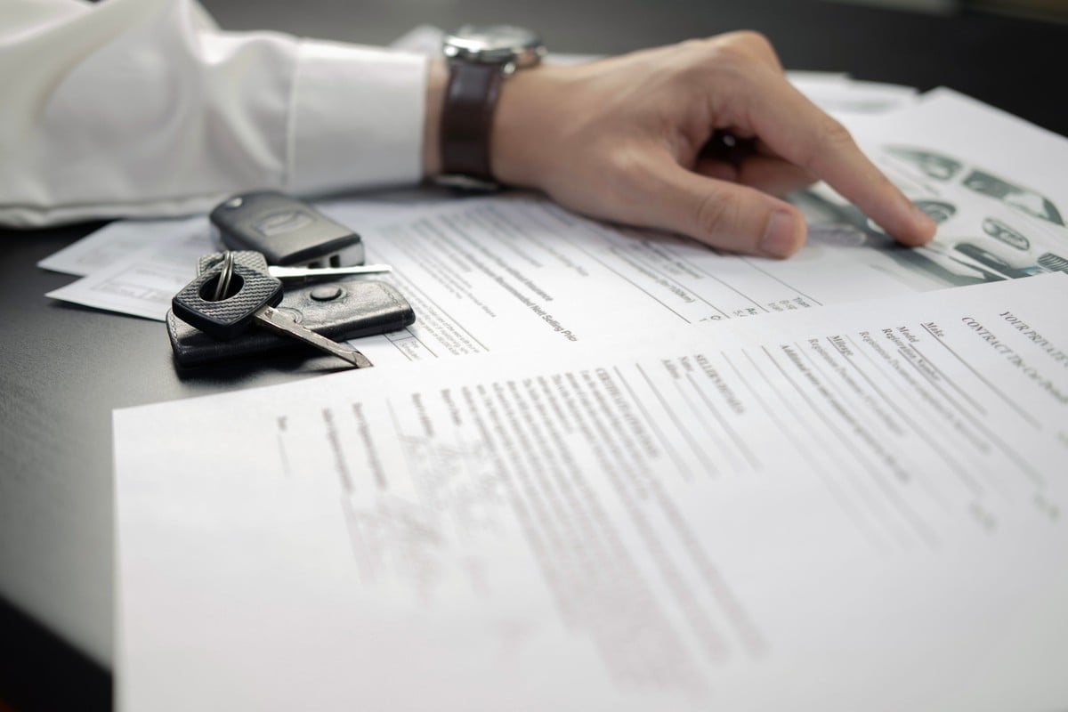 Corretor da Allianz analisando o contrato de um seguro auto    