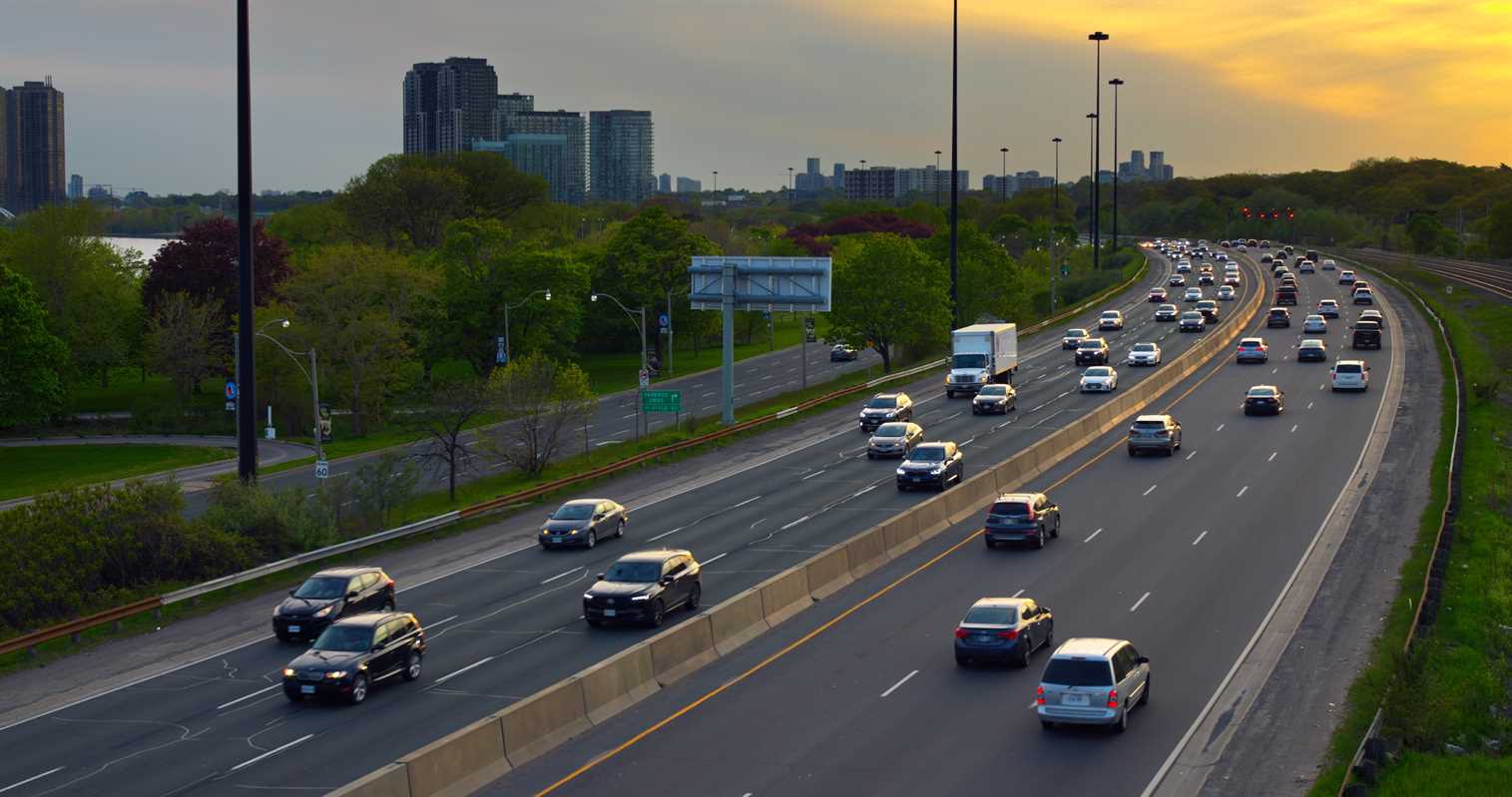 Avenida com diversos veículos transitando         