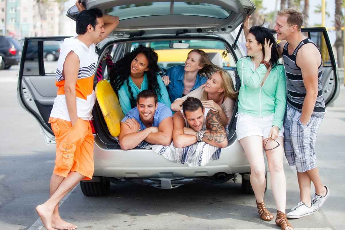 Grupo de pessoas dentro do porta malas de um carro    