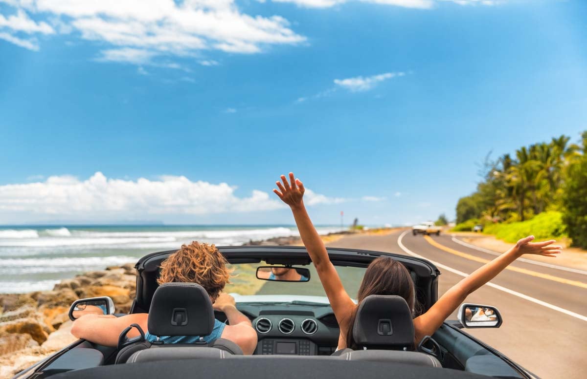 Casal dentro de um carro conversível        