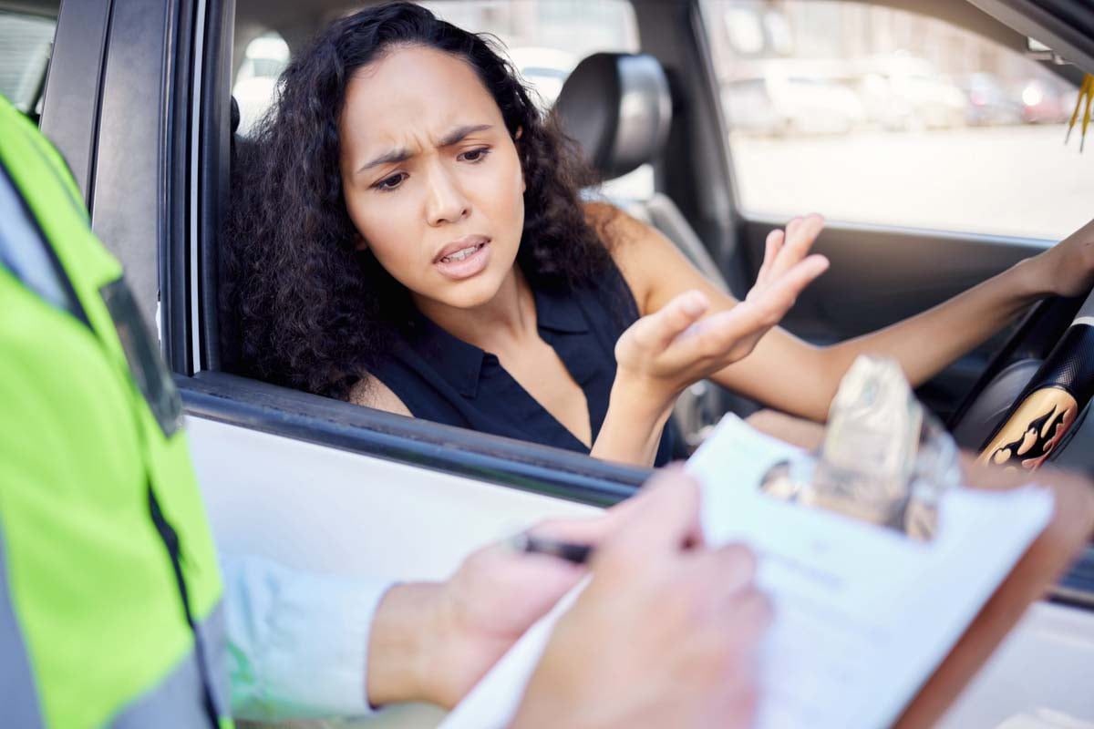 Motorista reagindo com surpresa ao ser multada       