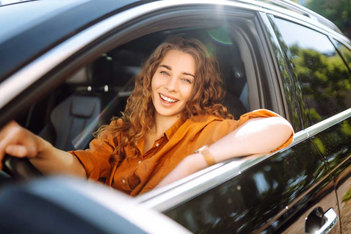  Mulher sorrindo ao volante