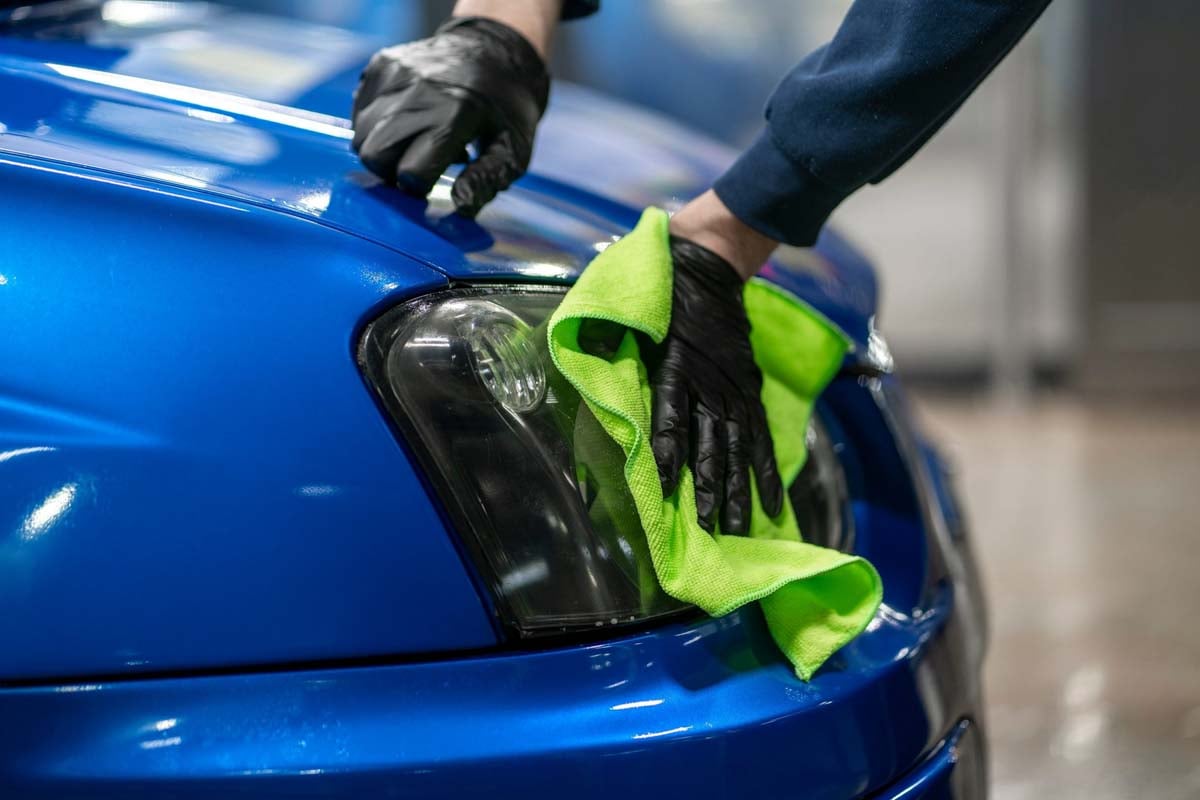 Profissional limpando o carro após envelopamento        