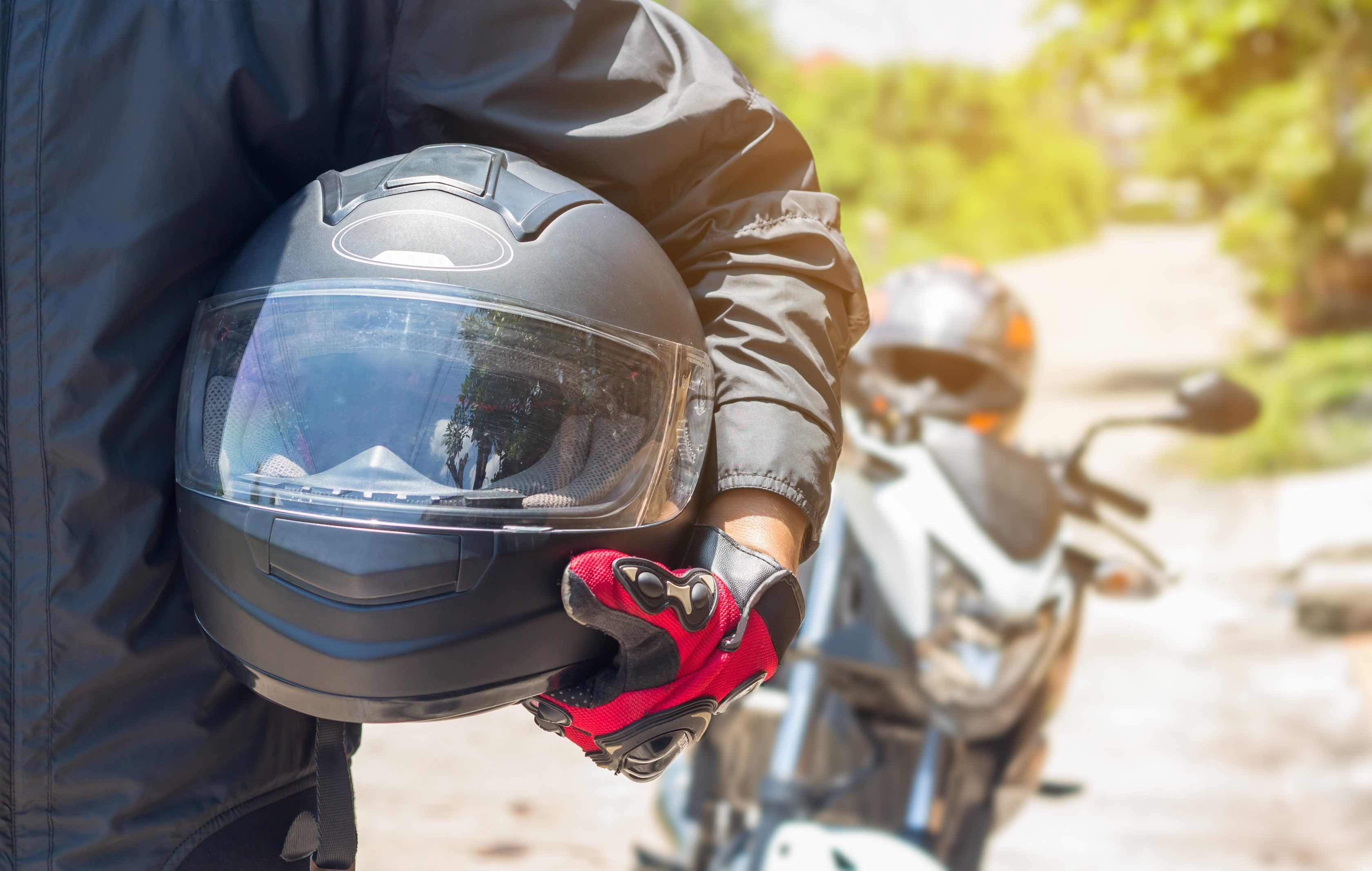Motociclista com capacete de moto em mãos