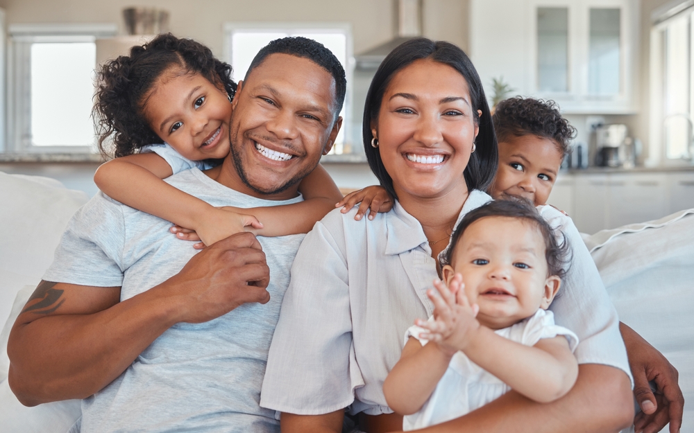Família feliz sorrindo sentados ao sofá