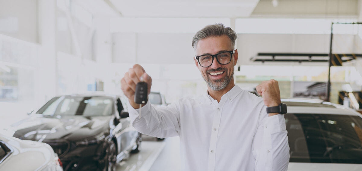 Homem feliz após a compra de um veículo