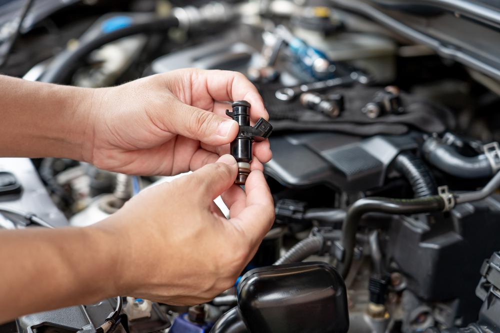 Mecânico removendo o bico injetor de gasolina do motor