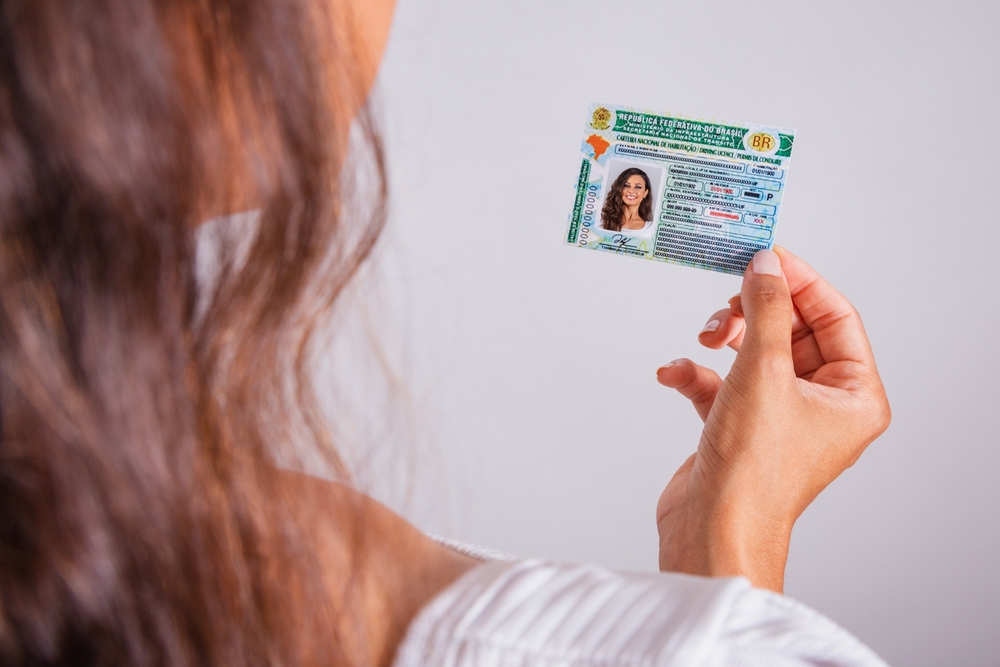 Mulher com sua carteira de motorista em mãos