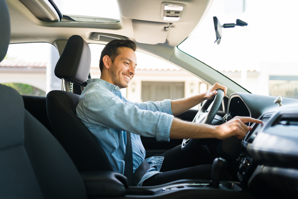 Homem sorrindo dentro de seu carro