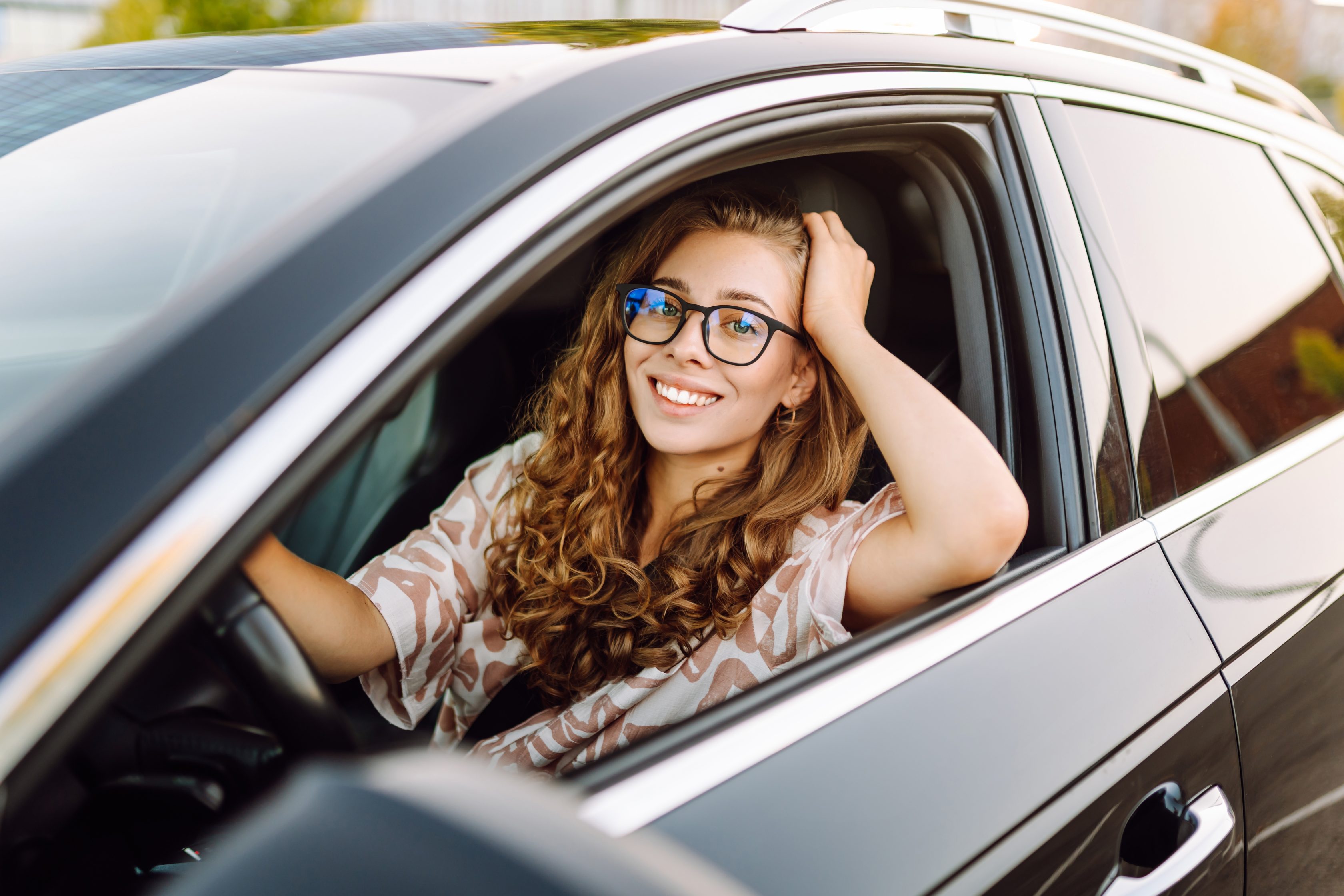 Jovem motorista de óculos sorrindo ao volante