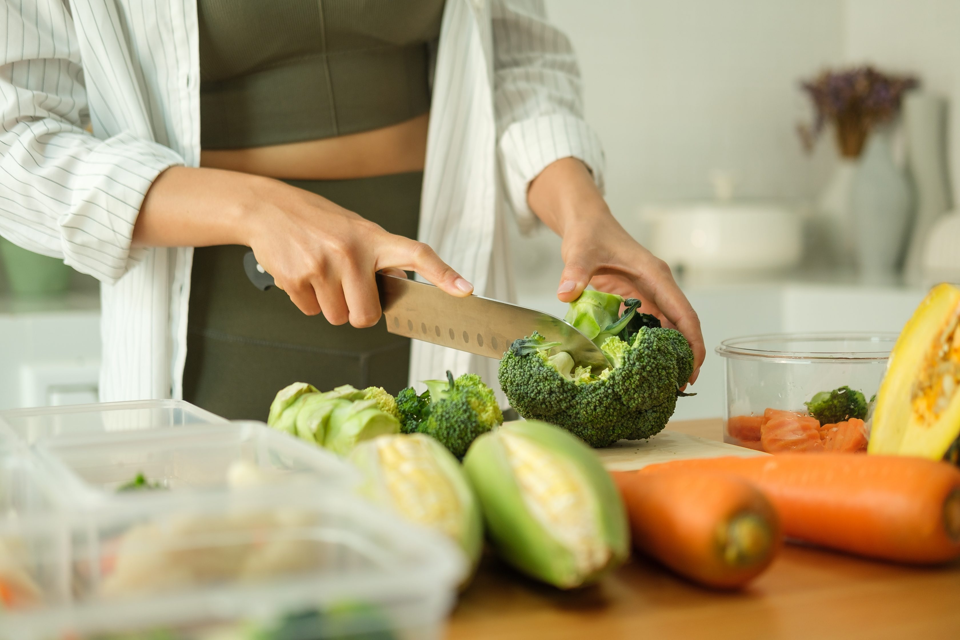 Mulher cortando alimentos saudáveis