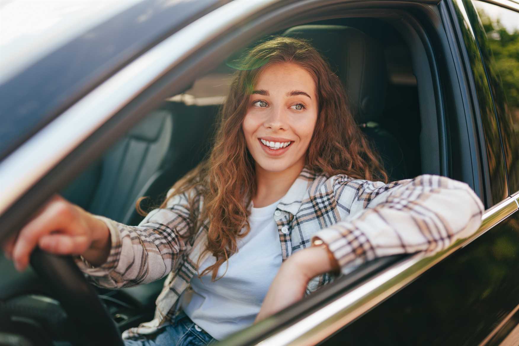 Mulher sorrindo e dirigindo o carro