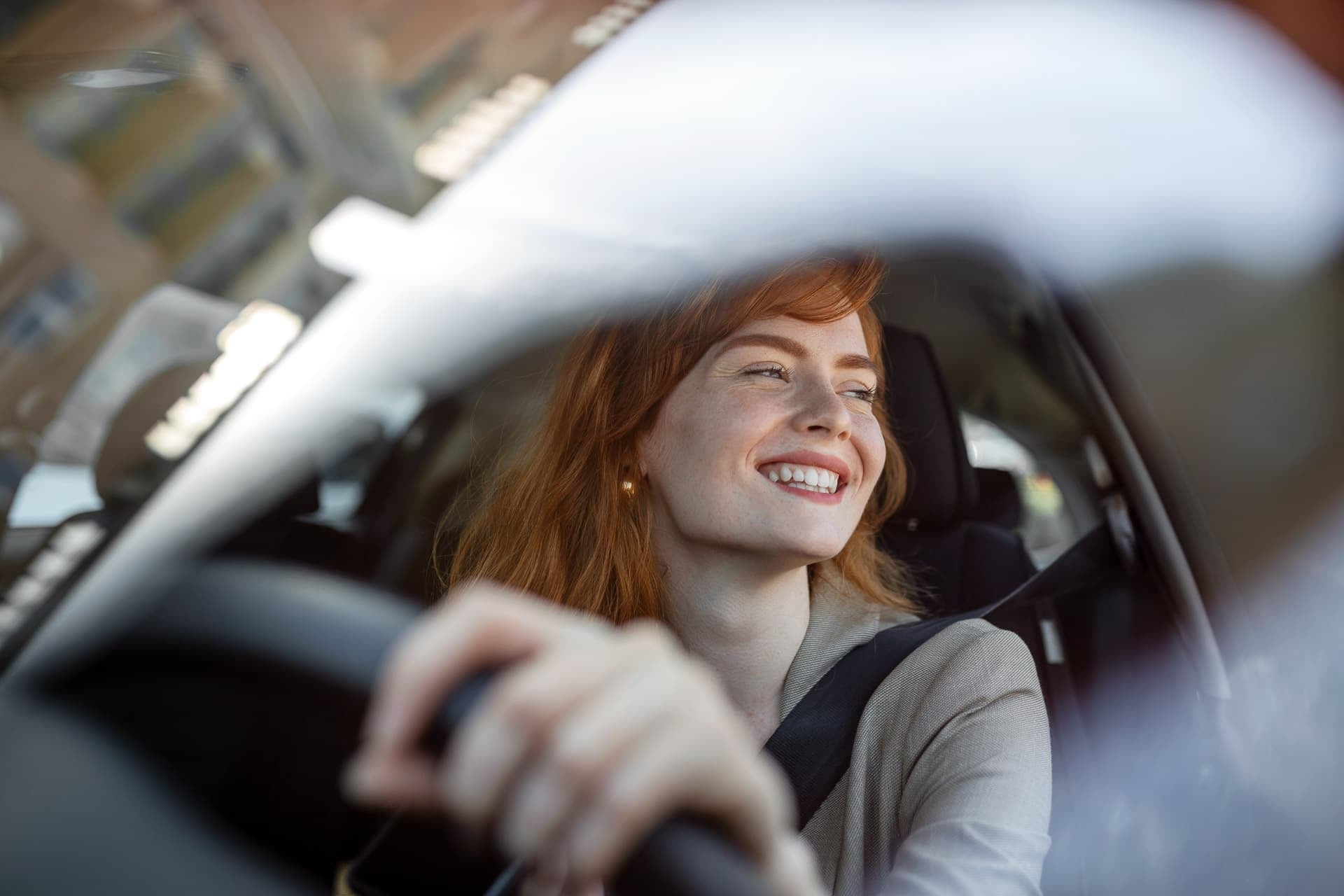  Mulher sorrindo e dirigindo seu carro  