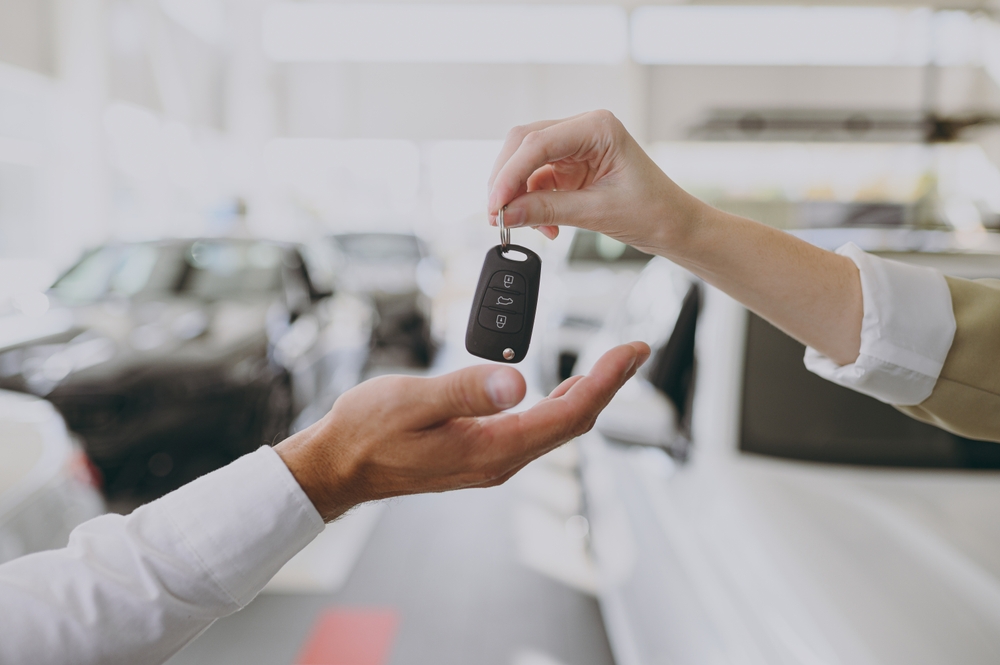 Pessoa recebendo a chave de seu novo carro