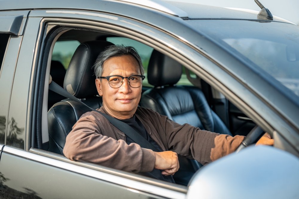 Homem sorrindo em seu carro