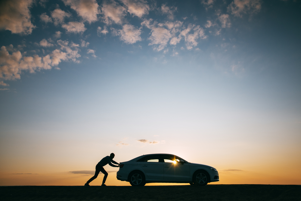 Homem empurrando seu carro